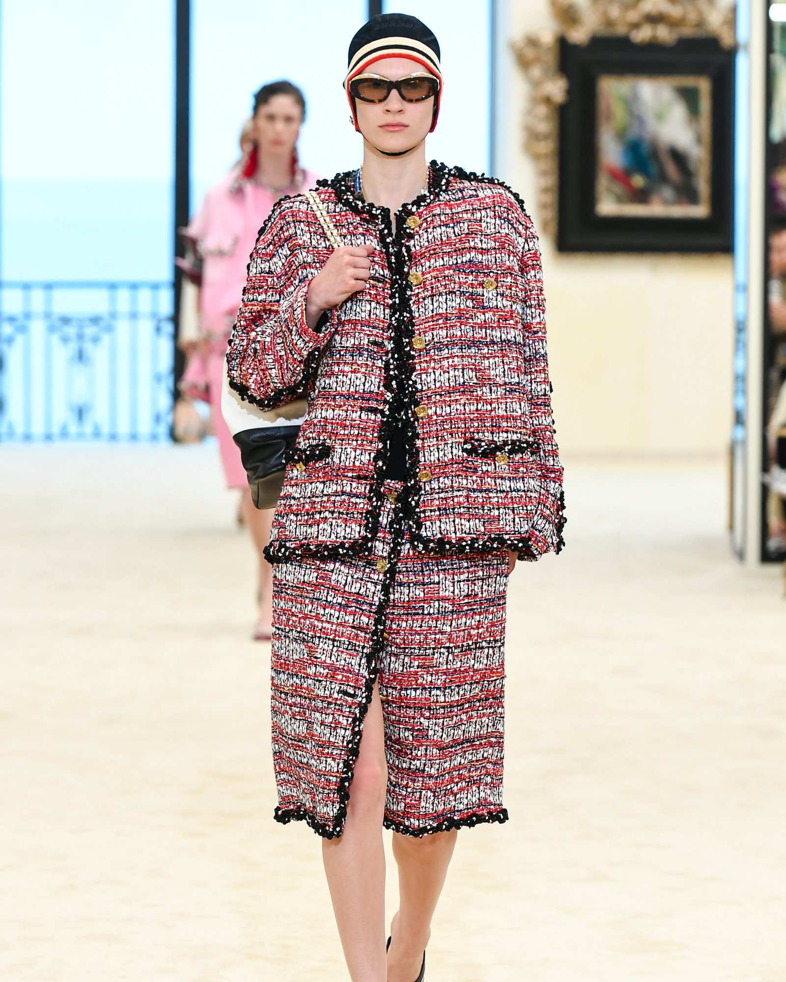 Chanel Cruise 2027 — the red-and-white CC swim cap stripe look, Biarritz.