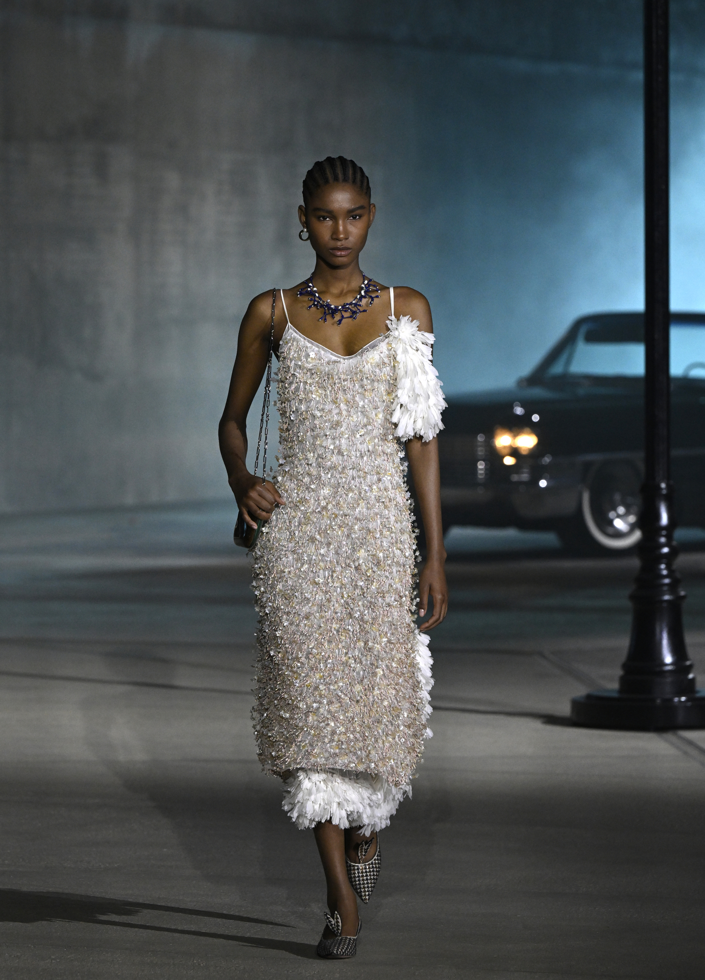 Dior Cruise 2027 — Cadillac fleet on the reproduced Wilshire Boulevard intersection inside LACMA David Geffen Galleries, Zumthor travertine in the background.