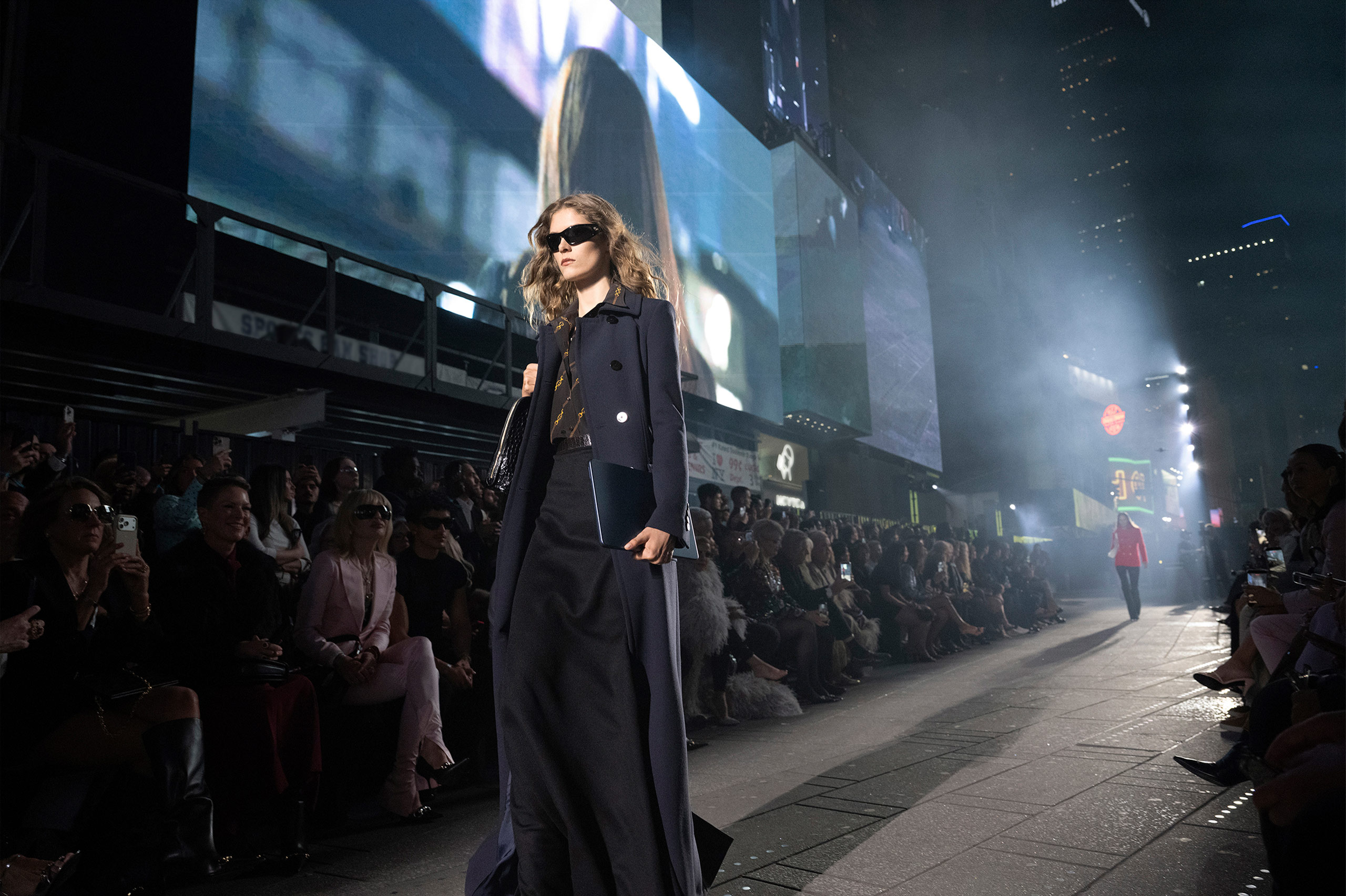 Gucci Cruise 2027 — Times Square full block runway, LED billboards visible above the runway, crowd extending several blocks.